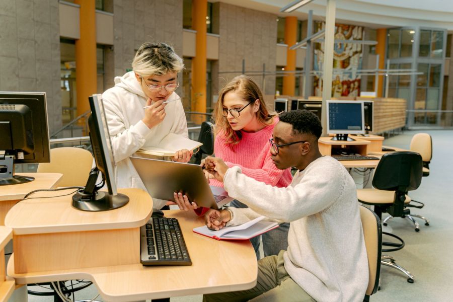 University students reviewing work together at a computer terminal